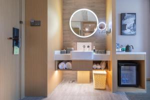 a bathroom with a sink and a mirror at Atour Hotel Wuhan Yellow Crane Tower in Wuhan