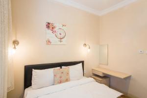 ein Schlafzimmer mit einem Bett und einer Uhr an der Wand in der Unterkunft Divan Wooden Guesthouse in Istanbul