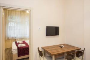 ein Esszimmer mit einem Tisch und einem TV an der Wand in der Unterkunft Divan Wooden Guesthouse in Istanbul