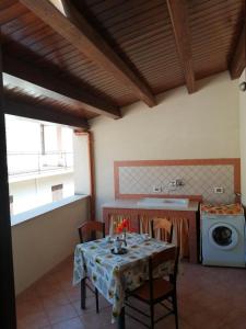 a kitchen with a table and a washing machine at Sandro Apartment in Castellammare del Golfo