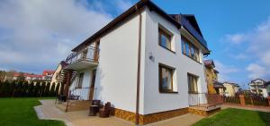 a white house with a gambrel roof at Willa Karol in Karwia