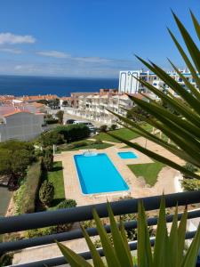 a view of a resort with a swimming pool and the ocean at See to Sea in Ericeira