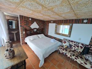 a bedroom with a bed and a brick wall at Parque Mirador del Chicamocha in Los Santos