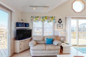 a living room with a couch and a tv at Charmed Life RO22 in Rodanthe