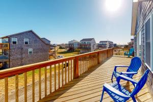 two blue chairs sitting on a deck on a house at Charmed Life RO22 in Rodanthe