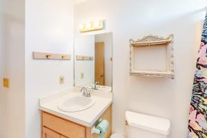a bathroom with a sink and a toilet and a mirror at Charmed Life RO22 in Rodanthe +24 photos