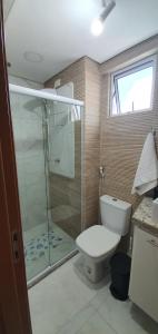 e bagno con servizi igienici e doccia in vetro. di Makambira Residence 201 a Porto De Galinhas