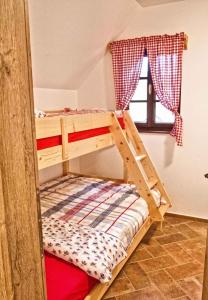 een houten stapelbed in een kamer met een raam bij Holiday home in Otocec Kranjska Krain 42903 in Otočec