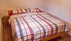 a bed with a striped comforter in a bedroom at Holiday home in Otocec Kranjska Krain 42903 in Otočec