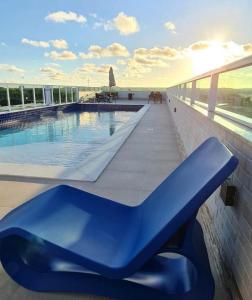 una panchina blu accanto a una piscina in un edificio di Makambira Residence 201 a Porto De Galinhas
