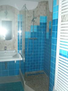 ein blau gefliestes Bad mit einer Dusche und einem Waschbecken in der Unterkunft Holiday home in Orosei Nuoro Provinz 39543 in Orosei