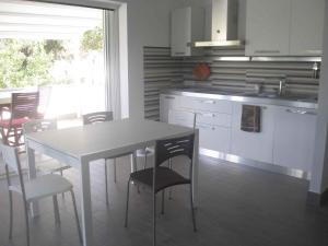 eine Küche mit einem Tisch und Stühlen in einer Küche in der Unterkunft Holiday home in Orosei Nuoro Provinz 39543 in Orosei + 11 Fotos