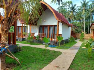 een huis met een palmboom ervoor bij Twiny's in Kuta Lombok