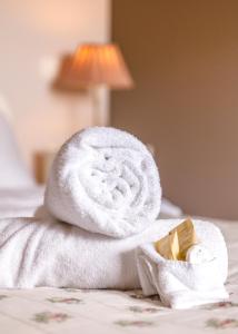 a rolled up towel on a bed with a towel at Chez Odile & Colin in Sulignat