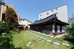 a building with a garden in front of a building at Dasomchae Hanok stay in Gwangju