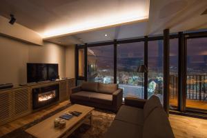 een woonkamer met een bank en een open haard bij Aspect Luxury Apartments by H2 Life in Kutchan