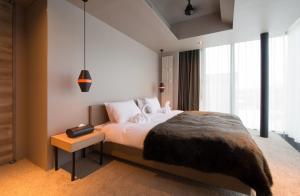 a bedroom with a bed and a large window at Aspect Luxury Apartments by H2 Life in Kutchan
