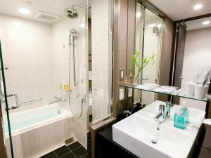 a bathroom with a sink and a shower and a tub at Hotel Brighton City Osaka Kitahama in Osaka