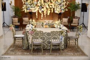- une table dans une pièce avec des chaises et des fleurs dans l'établissement Mahakam24 Residence, à Jakarta