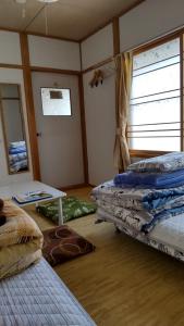 Habitación con 2 camas y mesa. en Guest House Yamada, en Date