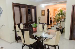 a dining room with a glass table and chairs at Pousada da Paz in Curitiba