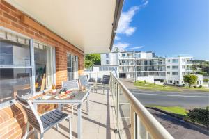 a balcony with a table and chairs and a building at Blue Vista 8 13 Victoria Parade - Studio with air con and spectacular views in Nelson Bay