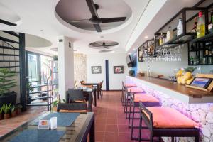 un ristorante con bar con tavoli e sedie di WaterColors Boracay Dive Resort a Boracay