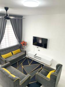 a living room with a couch and a tv at RS HOMESTAY BANDAR SERI ISKANDAR in Seri Iskandar