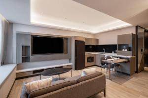 sala de estar amplia con sofá y cocina en Orchid Hotel en Singapur