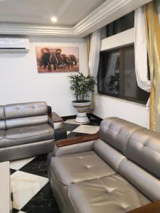 uma sala de estar com um sofá e uma mesa em RESIDENCE PALAIS DU STADE em Cotonou