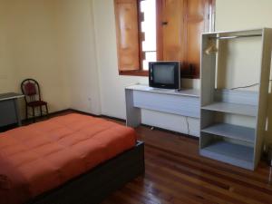 Schlafzimmer mit einem Bett und einem TV auf einem Schreibtisch in der Unterkunft Luxor in Arequipa