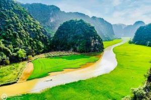 une rivière sinueuse dans un champ avec des montagnes en arrière-plan dans l'établissement Thăng Loan Tam Cốc Hostel, à Ninh Binh