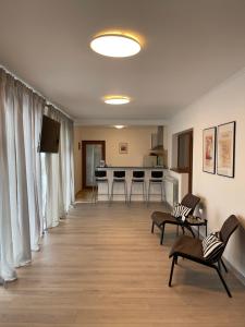 uma ampla sala de estar com cadeiras e uma cozinha em La Cupric em Sarichioi