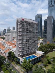 a tall building with a pool in front of a city at Orchid Hotel in Singapore