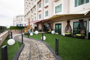 a building with balls on the grass in front of it at Ixora Hotel Penang in Perai