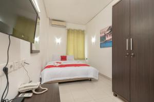 a bedroom with a bed and a phone in it at RedDoorz @ Tirta Mansion Karawaci in Galuga