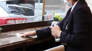 een vrouw in een pak zit aan een tafel bij Toyoko Inn Tokyo Fussa Ekimae Higashi guchi in Fussa