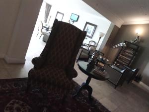 un soggiorno con sedia e tavolo di 131 on Herbert Baker Boutique Hotel a Pretoria