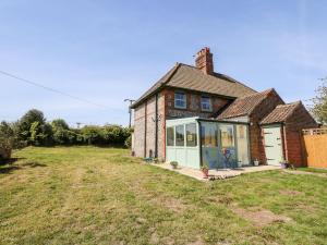 an old brick house with a yard in front of it at Owl Cottage in Norwich