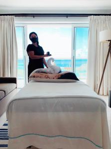 a person wearing a mask standing next to a bed at Beachfront Bella Horizonte 4 in Savaneta