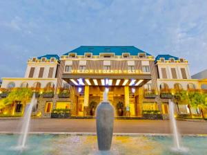a hotel with a fountain in front of a building at Viktor Legends Hotel in Móng Cái