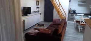 een woonkamer met een bruine bank en een televisie bij chez Christelle in Rochefort
