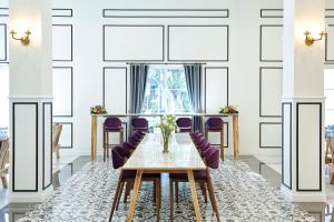 a dining room with a table and purple chairs at Villa De Pranakorn in Bangkok
