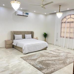 a bedroom with a large bed and a rug at UAE farm in Qūr