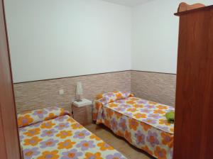 duas camas num pequeno quarto com em Casa ERIZO em Caleta de Sebo