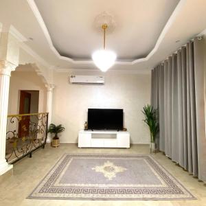 a living room with a television and a large rug at UAE farm in Qūr