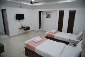 um quarto com duas camas e uma tv nele em Chandra Inn em Coulão