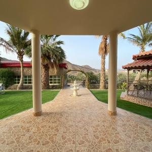 a courtyard with a fire hydrant and palm trees at UAE farm in Qūr