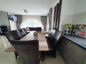 uma sala de jantar com uma mesa e cadeiras de couro em Casa Arini Bellevue em Vatra Dornei