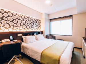 una camera d'albergo con letto, scrivania e finestra di Shinagawa Tobu Hotel a Tokyo